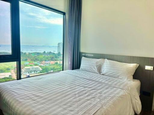 A bedroom with a large bed and a stunning view from the window