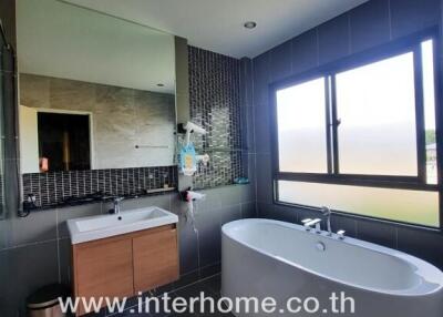 Modern bathroom with large window, bathtub, and vanity