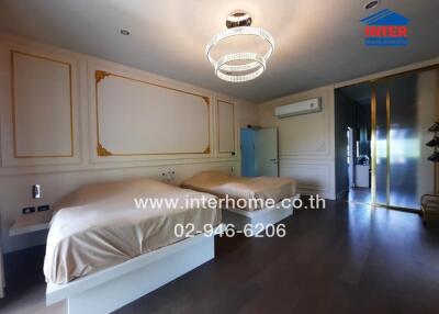 Spacious bedroom with two beds, modern decor and lighting