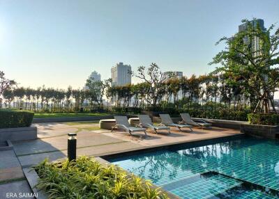 Luxurious outdoor pool area with sun loungers and skyline view