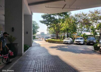 building entrance with paved driveway and parking area