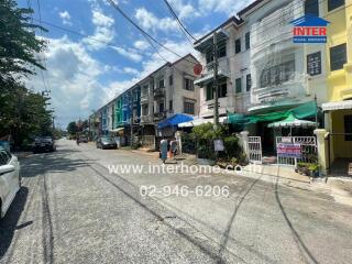 Street view of residential buildings with real estate signs