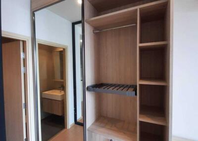 Bedroom closet with mirror doors and wooden shelves