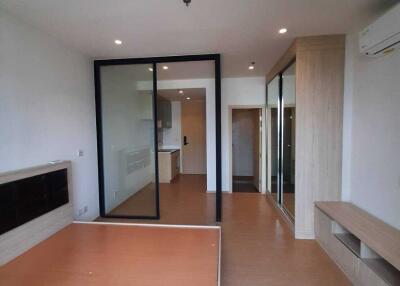 Modern bedroom with wooden flooring, large window, and glass partition