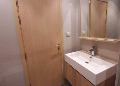 Modern bathroom with wooden door and vanity mirror