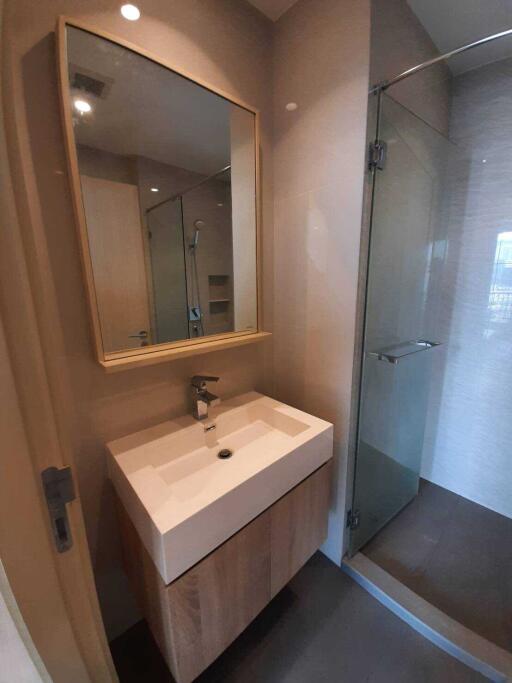 Modern bathroom with a wooden vanity and glass shower