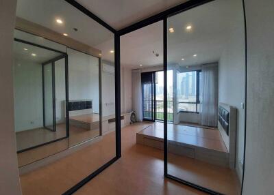 Bedroom with mirrored sliding doors and a city view