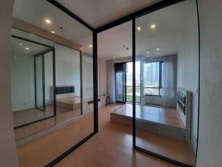 Bedroom with mirrored sliding doors and a city view