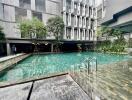 Outdoor pool area with modern building in the background