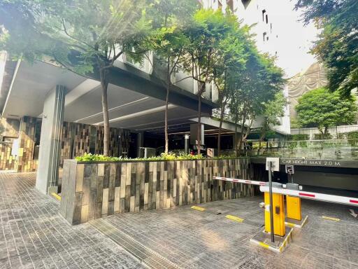 Modern building entrance with greenery and parking gate