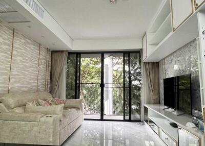 Spacious living room with large glass doors, modern decor, and comfortable sofa