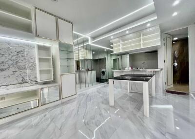 Modern kitchen with marble floors and backsplash, built-in appliances, and sleek cabinetry.