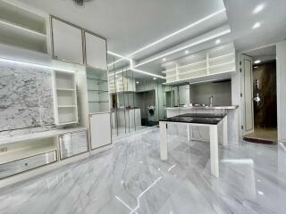 Modern kitchen with marble floors and backsplash, built-in appliances, and sleek cabinetry.