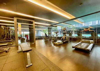 Modern gym with various exercise equipment and large windows