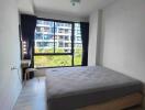 Bedroom with large window and simple furnishings