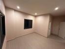 Empty bedroom with tiled floor and recessed lighting