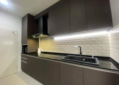 Modern kitchen with sleek dark cabinets and white subway tile backsplash