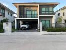 Front view of a modern two-story house with a car in the driveway