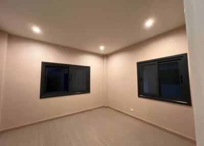 Spacious empty bedroom with large windows and recessed lighting.