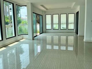 Spacious living room with large windows and tiled floor