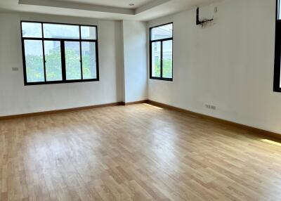 Spacious living room with large windows and wooden floor