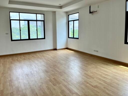 Spacious living room with large windows and wooden floor