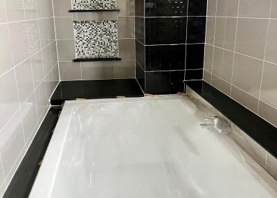 Modern bathroom with new bathtub and stylish tiling
