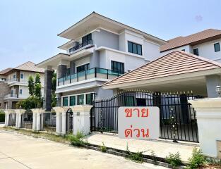 Front view of a modern multi-story house with a gated entry