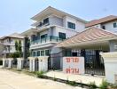 Front view of a modern multi-story house with a gated entry