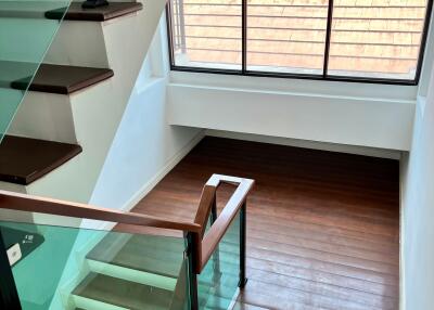 Staircase with wooden steps and glass railing