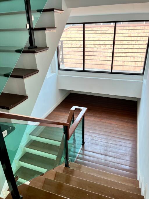 Staircase with wooden steps and glass railing