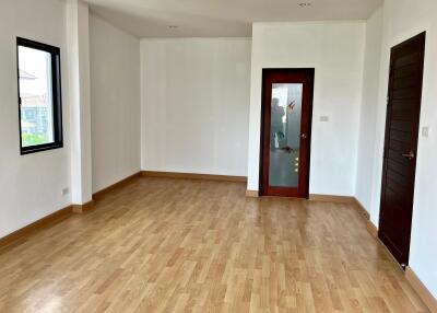 Spacious empty living room with wooden floor and large windows
