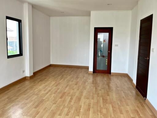 Spacious empty living room with wooden floor and large windows