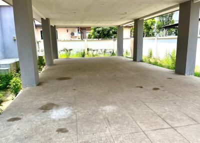 Covered parking area with tiled floor and supporting pillars