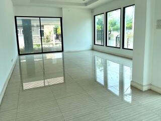 Spacious main living area with large windows and tile flooring