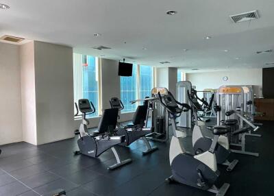 Well-equipped gym with modern exercise machines and large windows