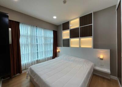 Modern bedroom with large window and decorative lighting