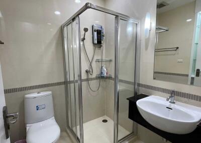 Modern bathroom with glass shower enclosure, toilet, and sink