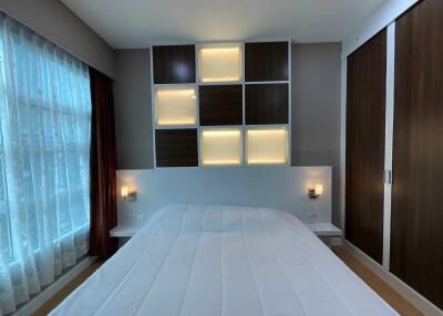 Modern bedroom with built-in storage and soft lighting