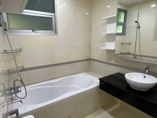 Modern bathroom with bathtub, sink, and shelves