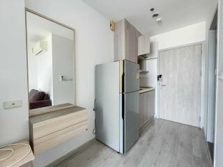 Modern kitchen area with fridge and cabinets