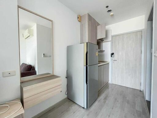 Modern kitchen area with fridge and cabinets