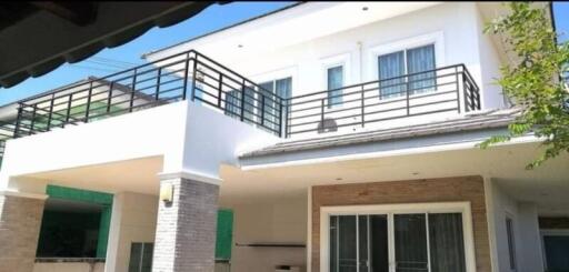 Exterior view of a modern two-story house with balcony and large windows