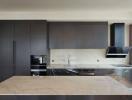 Modern kitchen with marble countertops and sleek black cabinetry