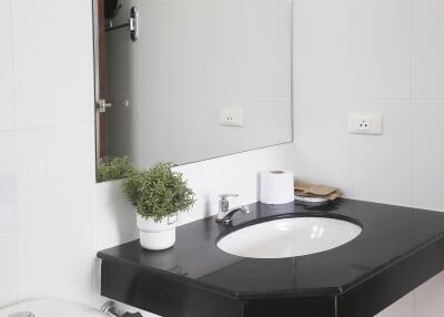 Modern bathroom with black countertop and mirror