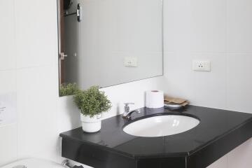 Modern bathroom with black countertop and mirror