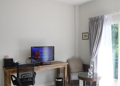 Bright bedroom with a work desk and TV