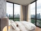 Modern bedroom with large windows offering a city view