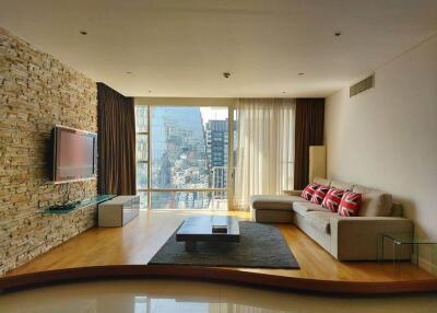 Modern living room with large windows, stone accent wall, and city view