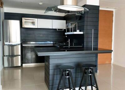 Modern kitchen with black and white cabinetry, stainless steel appliances, and breakfast bar